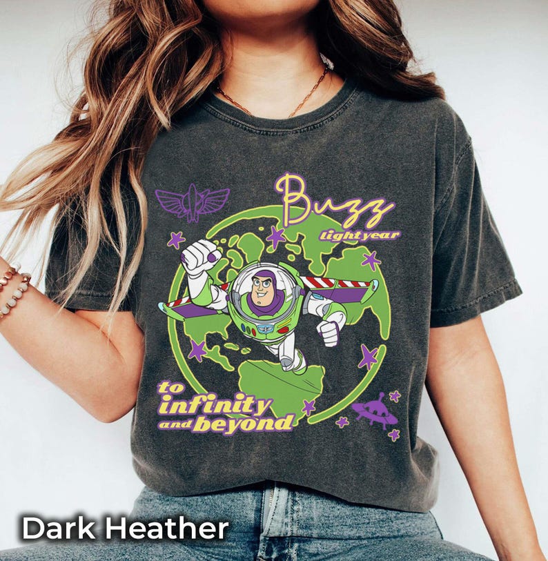 Puede incluir: Camiseta gris jaspeado oscuro con un dise&ntilde;o de Buzz Lightyear de Toy Story. El dise&ntilde;o incluye a Buzz Lightyear con un traje espacial verde y blanco, las palabras "Buzz Lightyear" y la frase "to infinity and beyond".