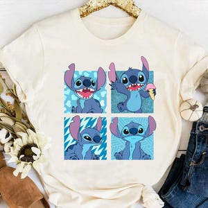 Puede incluir: Una camiseta blanca con un personaje de dibujos animados azul en cuatro poses diferentes. El personaje es Stitch de la pel&iacute;cula de Disney Lilo & Stitch. Cada Stitch est&aacute; en un cuadrado de color diferente con un fondo estampado.
