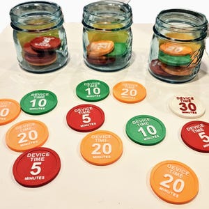 May include: Three glass mason jars filled with colorful tokens, labeled with "Device Time" and minute increments of 5, 10, 20, and 30. The tokens are red, green, orange, and white. The tokens are scattered around the jars.