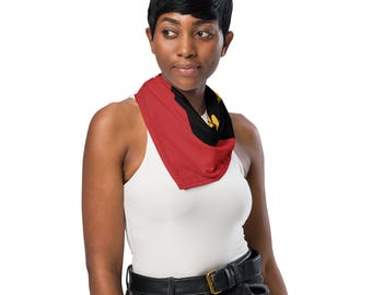Könnte beinhalten: Ein dreieckiges Bandana mit der Flagge von Angola, bestehend aus einem roten horizontalen Band auf der linken Seite und einem schwarzen Band auf der rechten Seite, mit einem gelben Emblem aus Zahnrad, Machete und Stern.