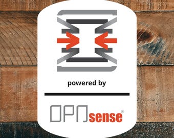 May include: A white rectangular sticker with rounded corners featuring a grey and orange geometric logo at the top. Below the logo, the text reads "powered by" followed by a horizontal black line and the text "OPNsense" in grey and orange.
