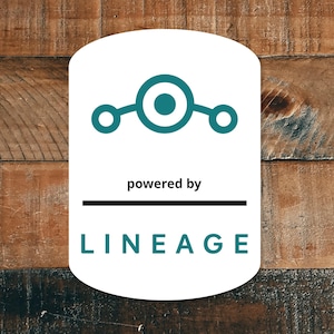 May include: A white, rounded rectangle featuring a teal graphic and the words "powered by" above a black line. Below the line, the word "LINEAGE" is displayed in teal. The background is a wooden surface.