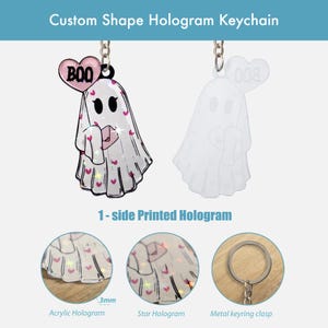 K&ouml;nnte beinhalten: Ein individuell geformter Hologramm-Schl&uuml;sselanh&auml;nger mit einem Geisterdesign. Der Geist ist wei&szlig; mit rosa Herzakzenten und einem rosa herzf&ouml;rmigen Ballon mit der Aufschrift "BOO". Der Schl&uuml;sselanh&auml;nger hat einen Metall-Schl&uuml;sselringverschluss und ist 3 mm dick.