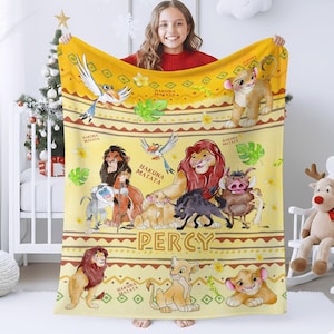 May include: A yellow fleece blanket featuring characters from The Lion King. The blanket has a repeating pattern of the phrase "Hakuna Matata" and illustrations of Simba, Timon, Pumbaa, and other characters. The name "Percy" is printed on the blanket.