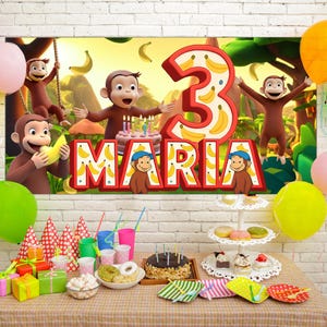 Può includere: Una scena di festa di compleanno con uno striscione con il numero 3 e il nome "Maria", a tema scimmia. Palloncini, una torta e articoli per feste su un tavolo. Lo striscione presenta una scimmia dei cartoni animati e banane.
