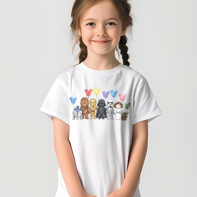 Puede incluir: Camiseta blanca con un gr&aacute;fico colorido de personajes de Star Wars y globos con forma de Mickey Mouse. El dise&ntilde;o incluye a R2-D2, Chewbacca, C-3PO, Darth Vader, un Stormtrooper, la Princesa Leia y Grogu.