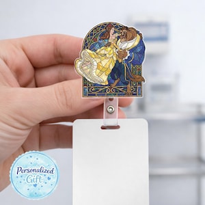 May include: A badge reel featuring a stained-glass design of Belle and the Beast dancing. The design includes yellow, blue, and brown colors. The badge reel has a white rectangular area for a name tag and the text "Personalized Gift".