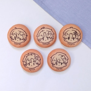 May include: Five round biscuits with cartoon character illustrations and names. Each biscuit features a different design, with a character sporting stylized hair and facial features. The names "Xavier", "Rafayel", "Zayne", "Sylus", and "Caleb" are written below each character.