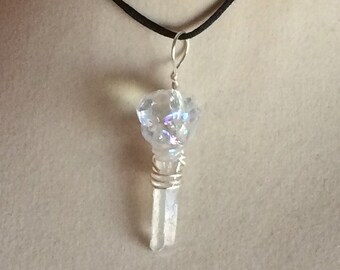 May include: A silver wire-wrapped crystal pendant with a clear iridescent crystal on top, hanging from a black cord.