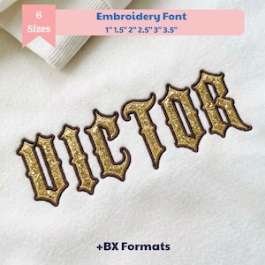 May include: An embroidery font design featuring the name VICTOR in a gold glitter texture with dark brown outlines. The text is displayed on a white fabric background. A pink banner at the top states 6 Sizes 1 inch 1.5 inch 2 inch 2.5 inch 3 inch 3.5 inch.