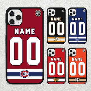 May include: Set of four phone cases featuring NHL hockey team jerseys. Each case has a different team logo and color scheme. The cases are all black with a clear back and a white border. The text "NAME 00" is printed on each case.