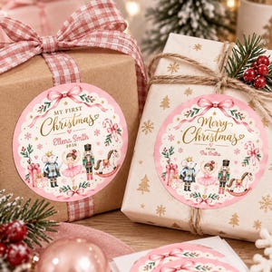 May include: Two round gift stickers with a scalloped pink border, featuring illustrations of a mouse, ballerina, nutcracker, and rocking horse. The left sticker reads My First Christmas Ellena Smith 2026, and the right reads Merry Christmas From The Smiths.