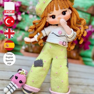 May include: A handmade crochet doll with red hair, wearing a green hat and pants with pink polka dots. The doll has a white shirt and a small pink accessory. The text "PDF PATTERN ONLY - NOT FINISHED DOLL" is at the bottom.