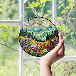 a hand holding up a stained glass picture