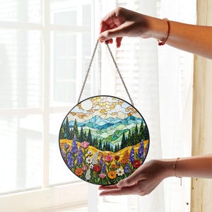 a person holding a stained glass window hanging from a chain
