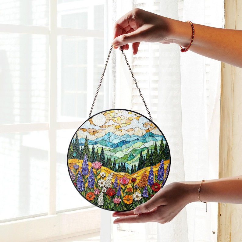 a person holding a stained glass window hanging from a chain