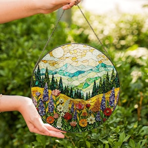 a hand holding a stained glass sun catcher