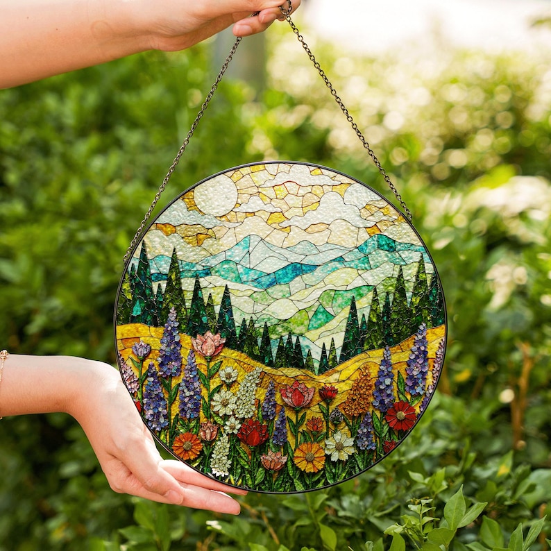 a hand holding a stained glass sun catcher