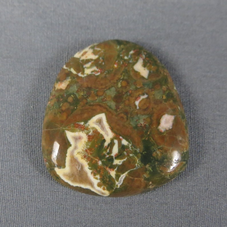 May include: A smooth, polished, green, brown, and white agate stone with a swirling pattern.