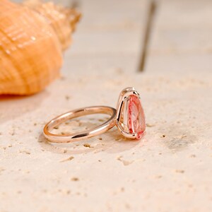 May include: A rose gold ring with a pear-shaped pink gemstone.