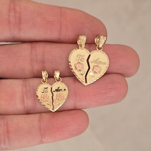 May include: Two gold-tone heart-shaped pendants with a broken heart design. The pendants are engraved with flowers and the word "Te" on one side and "Amo" on the other side.