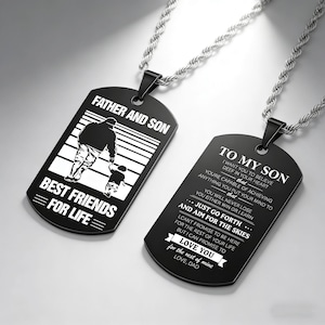 May include: Two black dog tag necklaces with silver chains. One tag reads "FATHER AND SON BEST FRIENDS FOR LIFE" with a graphic of a father and son. The other tag reads "TO MY SON" with a loving message from a father.