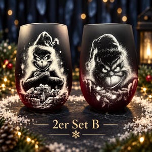 Könnte beinhalten: Ein Set aus zwei stielosen Weingläsern mit mattschwarzer Oberfläche und weißen geätzten Illustrationen einer mürrischen Figur mit Weihnachtsmütze. Ein Glas zeigt die Figur mit Geschenken, das andere ein Porträt der Figur.