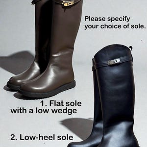 May include: A pair of dark brown knee-high boots and a pair of black knee-high boots, both featuring a decorative strap with a gold-tone metal buckle. Text reads: Please specify your choice of sole. 1. Flat sole with a low wedge. 2. Low-heel sole.