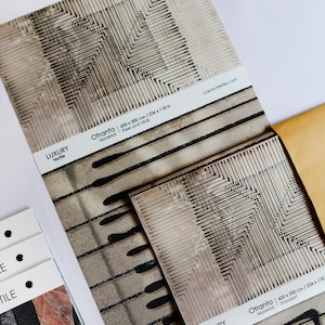 May include: Close-up of textile samples with geometric patterns in shades of gray and black. The samples include the text "Otranto" and "Luxury Textile". The dimensions are 236 x 118 inches.