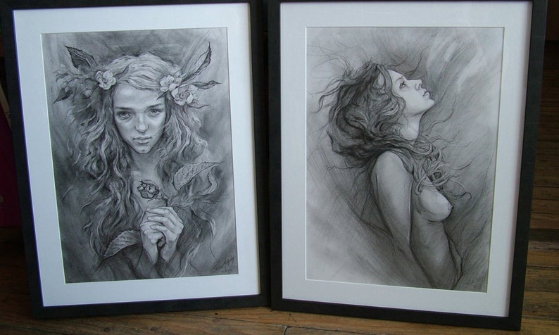 May include: Two framed black and white pencil drawings of women. The drawing on the left shows a woman with long hair and a floral crown holding a flower. The drawing on the right shows a woman with long hair looking up.