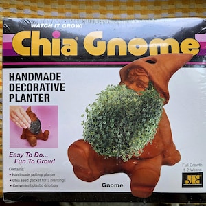 May include: A Chia Gnome handmade decorative planter in its original packaging. The box features the text 'WATCH IT GROW!', 'Chia Gnome', 'HANDMADE DECORATIVE PLANTER', and 'Easy To Do... Fun To Grow!'. It shows a terracotta gnome with green sprouts.