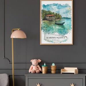 May include: A framed watercolor print of Karimunjawa, Indonesia, depicts a stilt house over turquoise water with a small boat. The print is in a light wood frame, hanging above a gray dresser with a pink pig stuffed animal, wooden cups, and a miniature wooden couch.