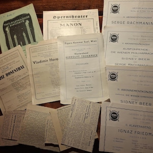 Könnte beinhalten: Eine Sammlung alter Konzertprogramme und Ephemera mit deutschem Text. Die Artikel umfassen Programme für Aufführungen von Serge Rachmaninoff, Ignaz Friedman und anderen. Die Papiere sind gealtert und haben einen Sepia-Ton.