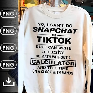 Può includere: Una felpa girocollo color crema con testo nero che recita: NO, I CAN'T DO SNAPCHAT OR TIKTOK BUT I CAN WRITE IN CURSIVE DO MATH WITHOUT A CALCULATOR AND TELL TIME ON A CLOCK WITH HANDS. Il capo presenta maniche lunghe e un colletto a coste.