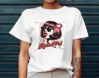 Può includere: T-shirt bianco con un'illustrazione in stile retrò di una donna con occhiali da sole e un lecca-lecca. La grafica include il testo "Retro Girl" in un font stilizzato, con un cuore e una stella.