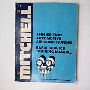 May include: A blue cover for a 1984 edition Mitchell Automotive Air Conditioning Basic Service Training Manual. The cover features a diagram of gauges and hoses.
