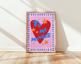 May include: A pink and red heart-shaped print with the text "Tu Me Manques" in blue and white lettering. The print is surrounded by a blue and white border and features orange stars.