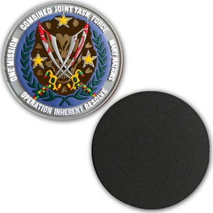 May include: A round, silver-edged coaster featuring the Combined Joint Task Force emblem. The emblem includes text that reads "ONE MISSION MANY NATIONS OPERATION INHERENT RESOLVE". The coaster has a black, circular base.