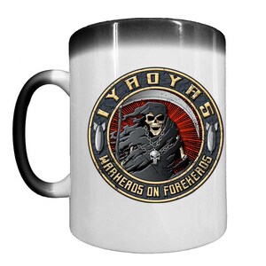May include: White ceramic mug with a black handle and rim. The mug features a circular graphic with a grim reaper holding a scythe, the text "IIYAOYAS" and "WARHEADS ON FOREHEADS" in a distressed style.