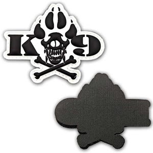 May include: Black and white K9 patch featuring a paw print, skull, and crossbones design. The patch has a white border and a black backing. The letters "K9" are prominently displayed.