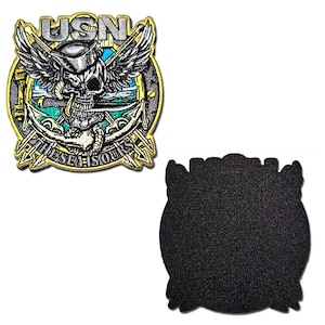 May include: Embroidered patch featuring a skull with wings, a naval anchor, and the text "USN" and "THE SEA SOULS". The patch has a gold border and a black backing. The skull is wearing a hat and holding a sword.