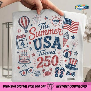 May include: A white fabric square featuring a red and blue graphic print with the text The Summer USA Turned 250. The design includes a hot air balloon, a July 4 calendar page, a cake, sunglasses, a flag, ice cream, a beach ball, a hat, and a crab.