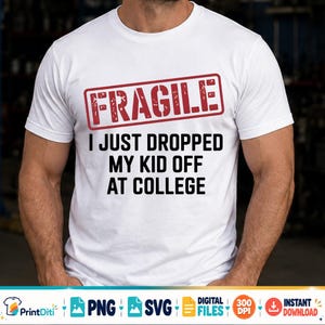 May include: A white short-sleeved t-shirt featuring a red rectangular stamp graphic with the word FRAGILE in white letters. Below the stamp, the text reads I JUST DROPPED MY KID OFF AT COLLEGE in bold black capital letters on the front of the shirt.
