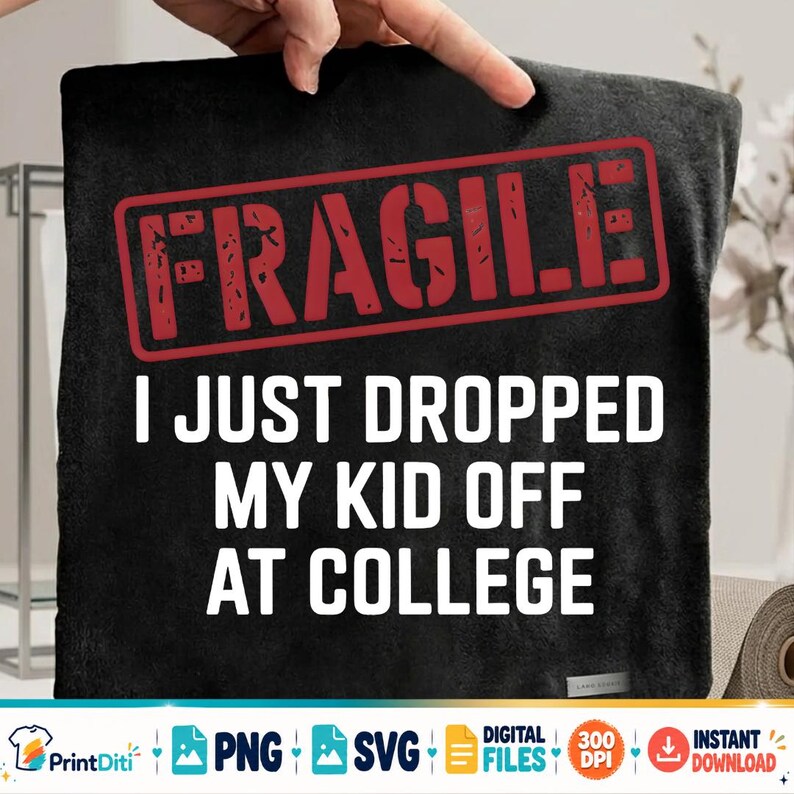 May include: A black blanket featuring a red rectangular stamp graphic with the word FRAGILE in distressed lettering. Below the stamp, white text reads I JUST DROPPED MY KID OFF AT COLLEGE. The fabric has a soft, textured appearance with a small label.