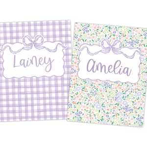 May include: Two notebooks, one with a lilac gingham pattern and the name "Lainey" in script, the other with a floral pattern and the name "Amelia" in script. Both have a decorative bow.