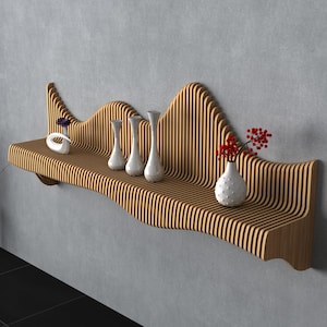 May include: A wooden wall shelf with a unique, undulating design, resembling a mountain range. The shelf holds several white vases with flowers and decorative objects. The shelf is mounted on a gray wall.