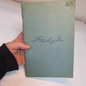 May include: A green book with the handwritten signature "G. McPherson" on the front cover.