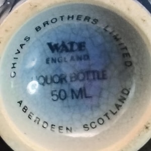K&ouml;nnte beinhalten: Nahaufnahme des Bodens einer hellblauen Lik&ouml;rflasche. Auf der Flasche steht "Chivas Brothers Limited" und "Wade England". Sie ist mit "Liquor Bottle 50 ML" und "Aberdeen Scotland" gekennzeichnet.