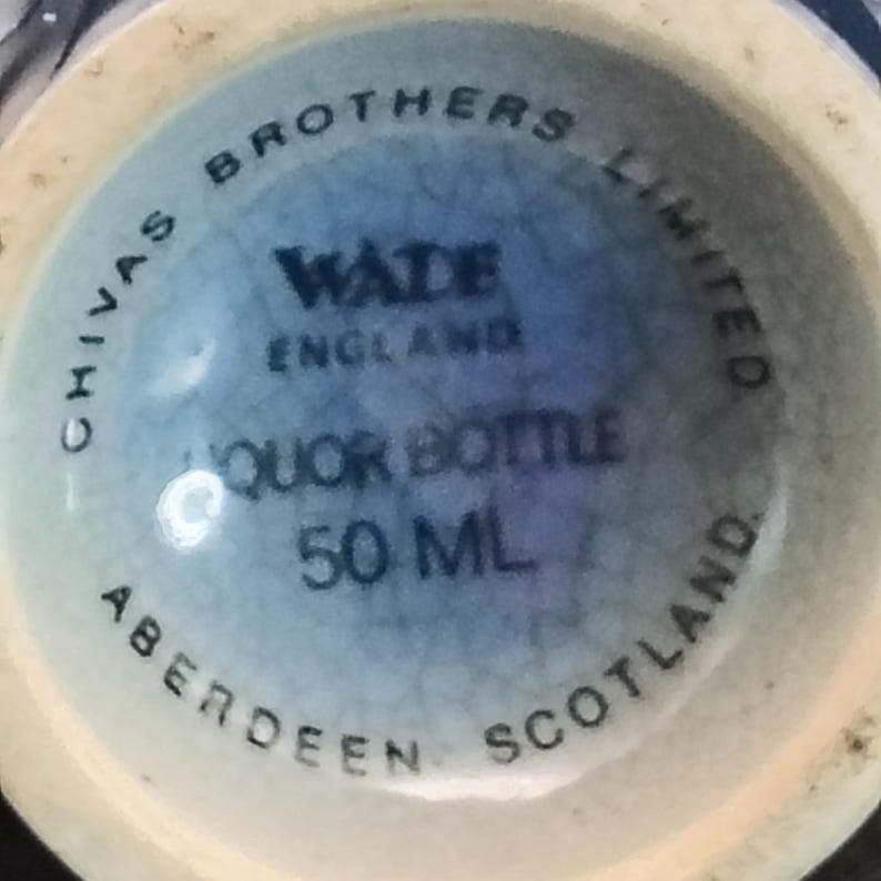 K&ouml;nnte beinhalten: Nahaufnahme des Bodens einer hellblauen Lik&ouml;rflasche. Auf der Flasche steht "Chivas Brothers Limited" und "Wade England". Sie ist mit "Liquor Bottle 50 ML" und "Aberdeen Scotland" gekennzeichnet.