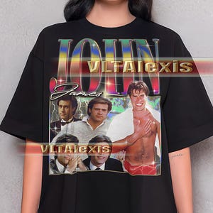 Puede incluir: Camiseta negra con un diseño retro. El gráfico presenta el nombre "JOHN" en una fuente de arcoíris, imágenes de un hombre y el texto "VLTALexis". Un diseño de inspiración vintage.